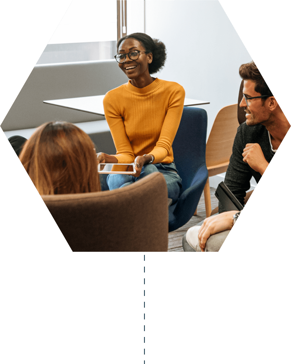 Four coworkers sitting in a circle, chatting casually and laughing