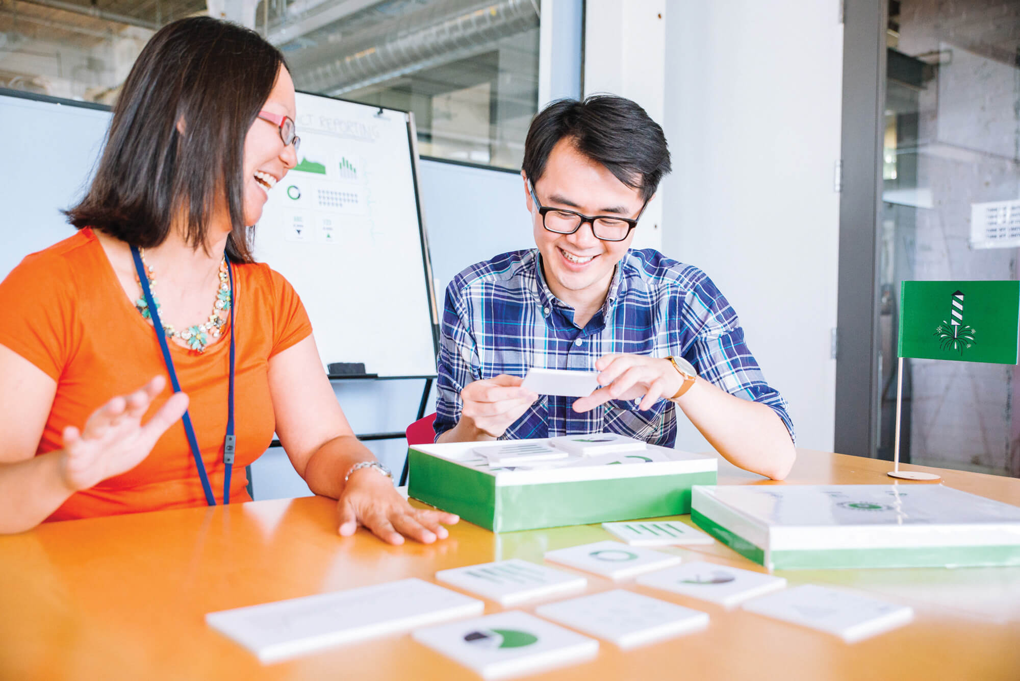 Two grantbook employees laughing and looking at a stack of cue cards