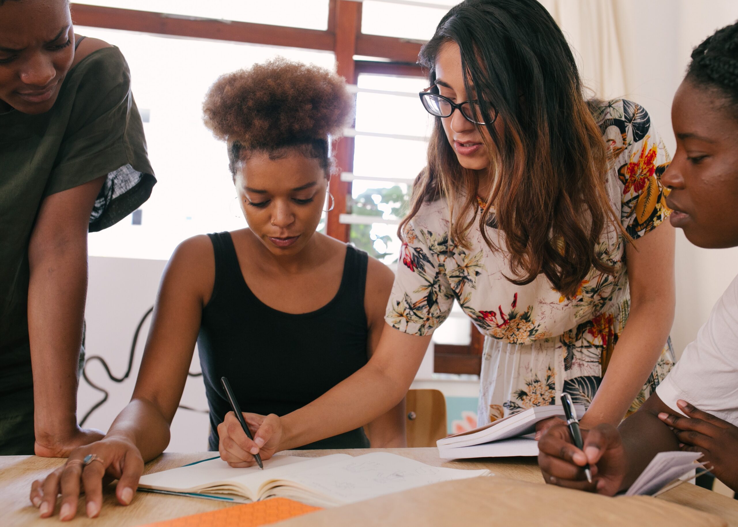 A photo of three employees clustered around a table, working on a project