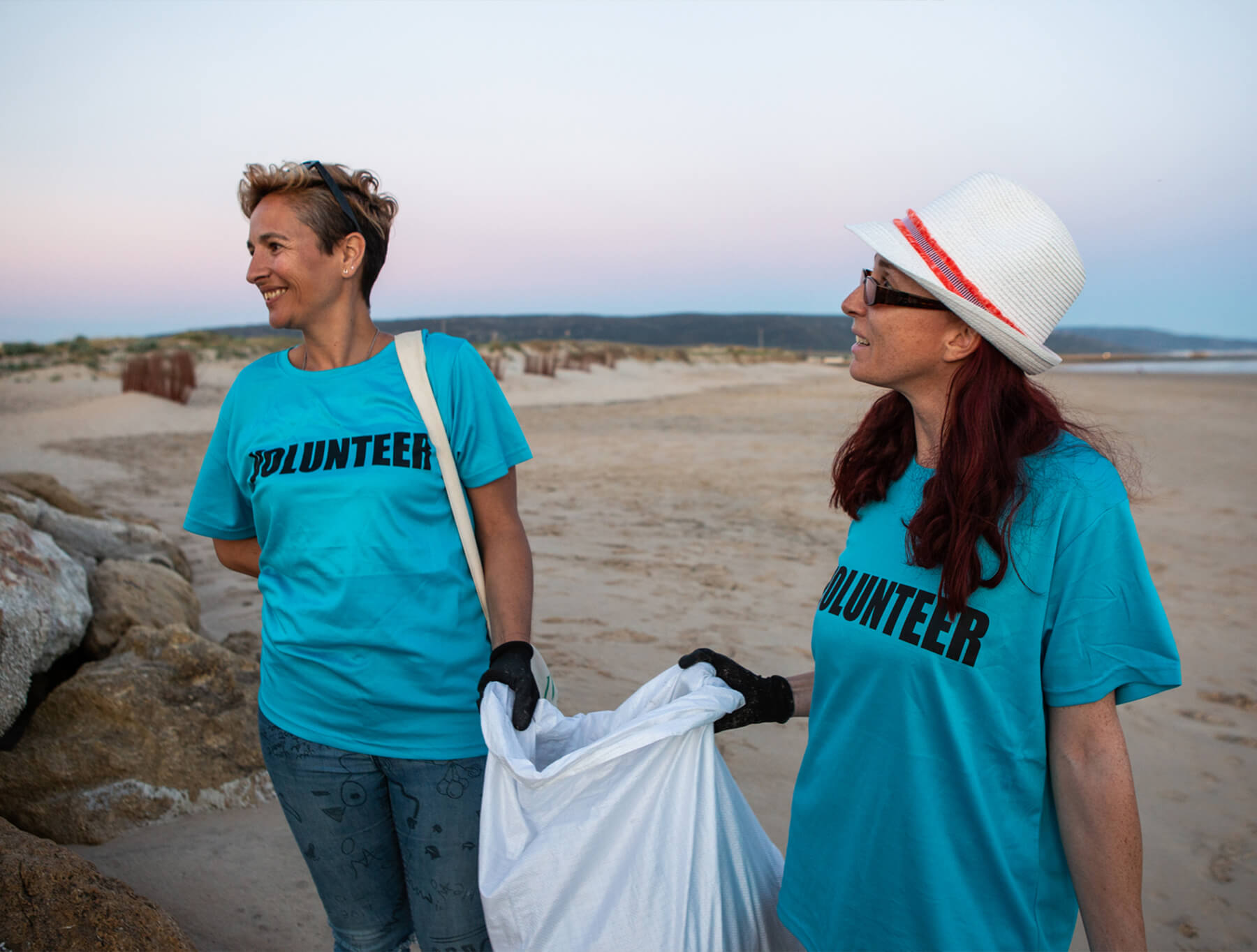 Two volunteers cleaning up the shore